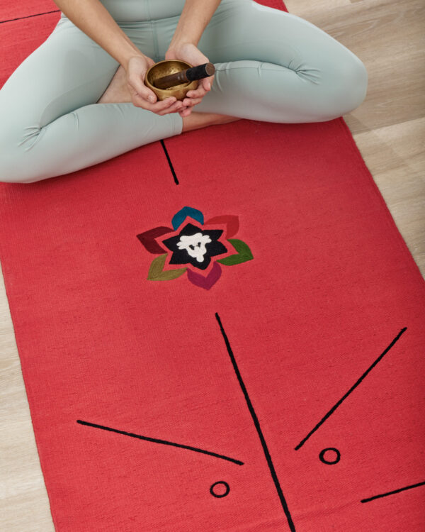 sitting on red yoga page with a bowl